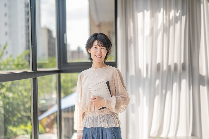 窓際に立っている笑顔の女性